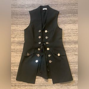 Long black vest with plastic American quarter replica buttons.